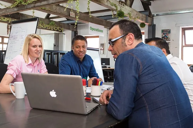 Team meeting around a laptop