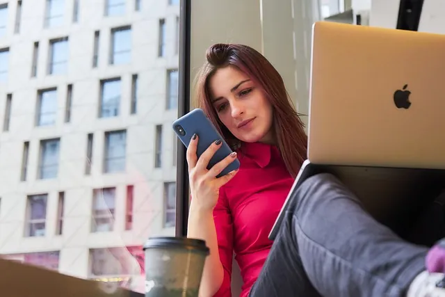 Professional working with a phone and a laptop